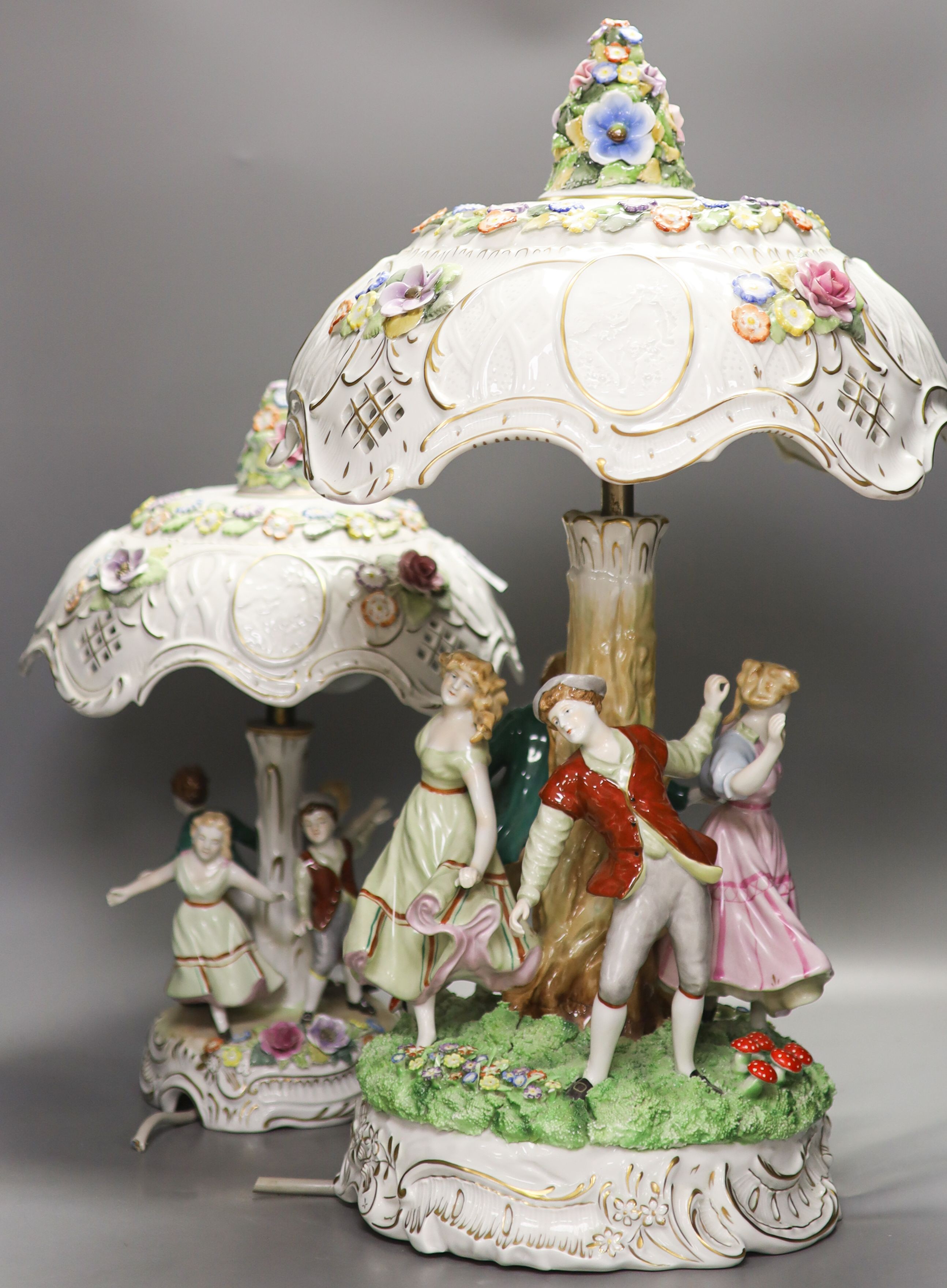 Two pairs of German porcelain table lamps, the stems modelled with figures dancing 56cm